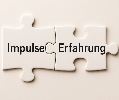 Zwei passende Puzzleteile mit den Worten 'Impulse' und 'Erfahrung' als Symbol für Coaching und Mentoring